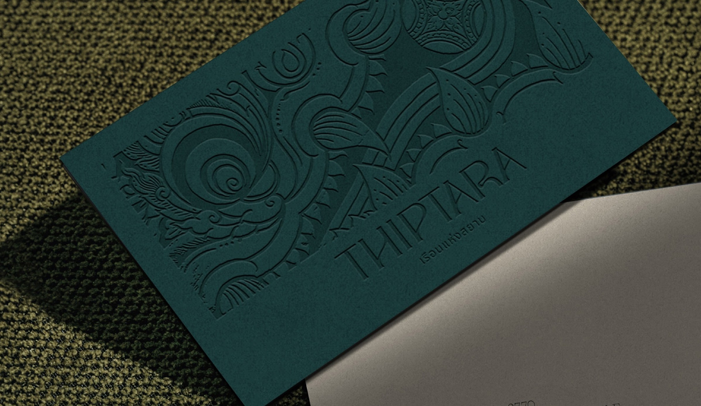 The Thiptara business card, embossed on teal